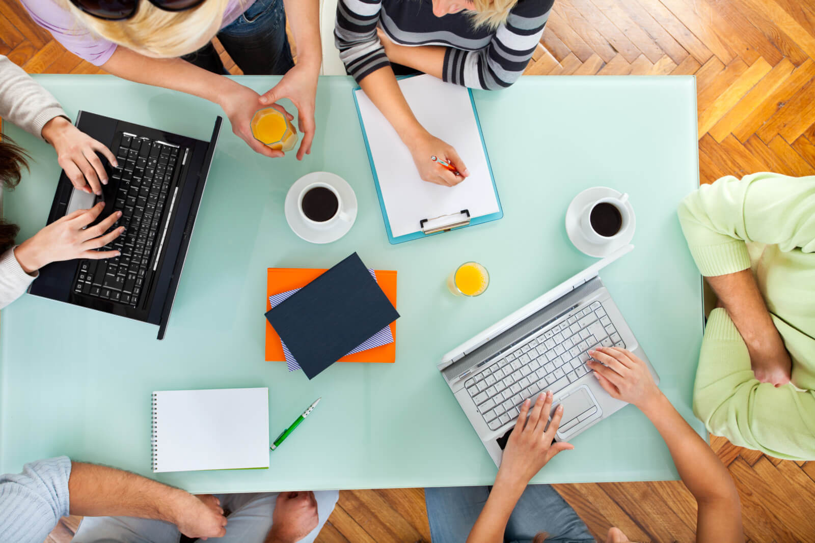 Group of people with two laptops at a meeting